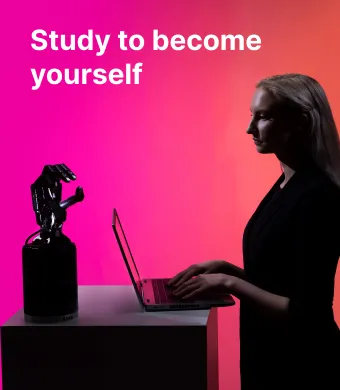 A student of the KTU Panevėžys Faculty of Technologies and Business works on a laptop next to a robotic arm against a pink and orange decorative background. On the left, the slogan “Study to become yourself” invites to choose studies at KTU Panevėžys Faculty of Technologies and Business.